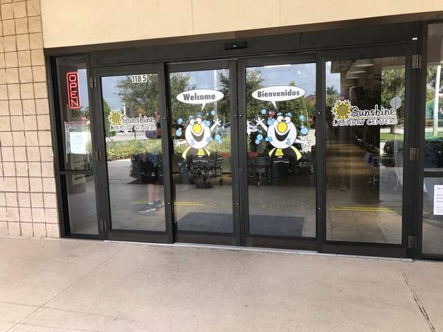 Clean exterior. Glass doors with Sunshine Laundry mascot image. Door reads Welcome and Bienvenidos.