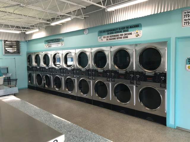16th Street Vero Beach. Row of front-loading washers. Blue interior, counter, clean.